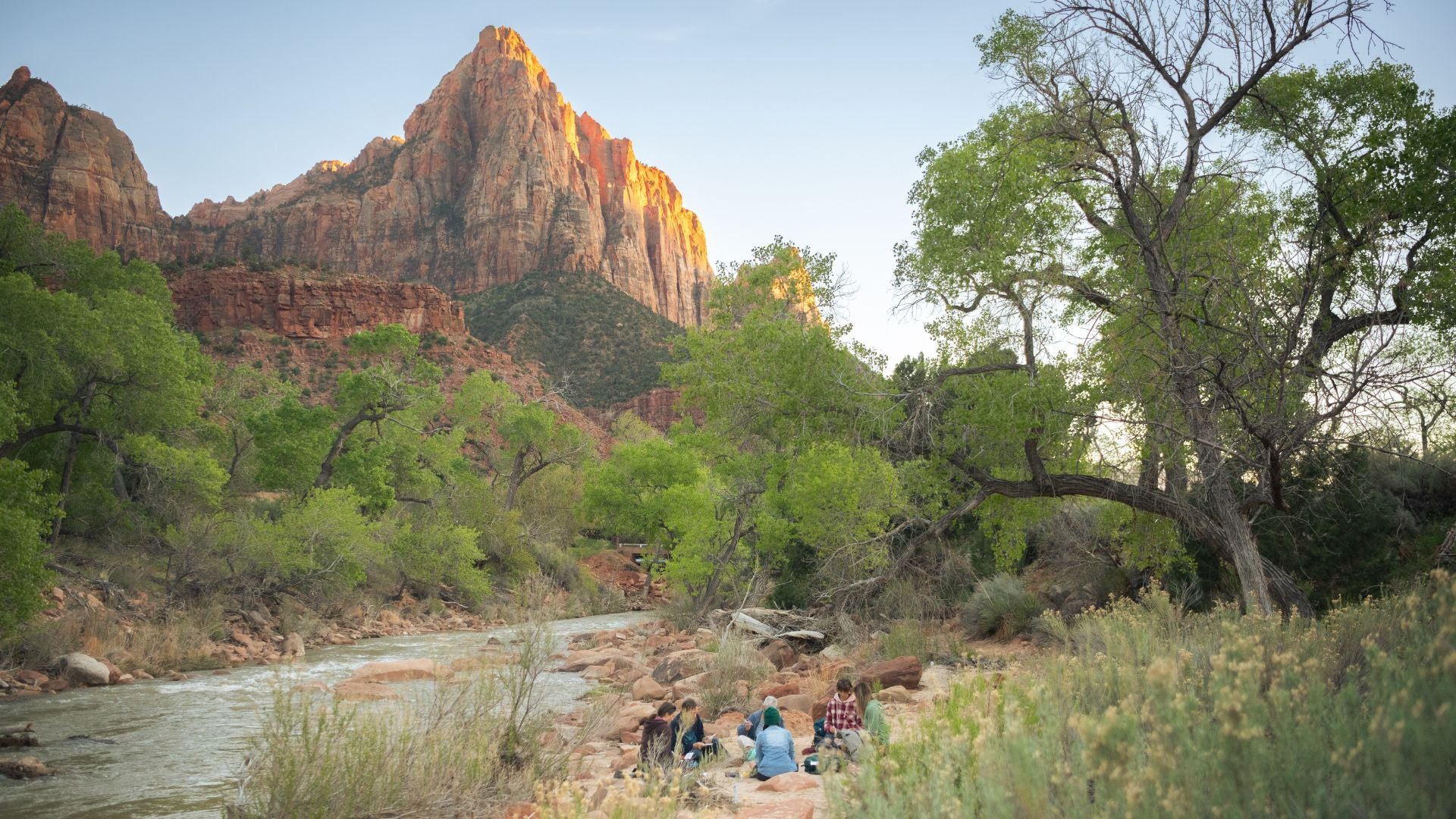 group sitting by the Virgin River in Zion National Park watercolor painting at sunset 